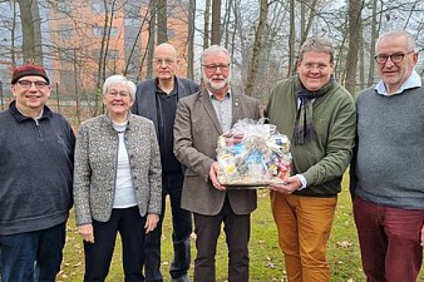 Mehrere Personen stehen gemeinsam in einem Raum